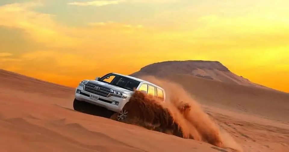 Land Cruiser dune bashing at sunset in the Abu Dhabi desert