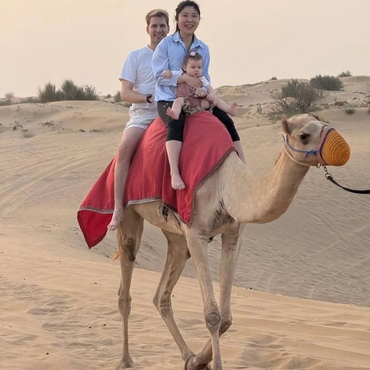 A family sharing a camel ride in the Abu Dhabi desert