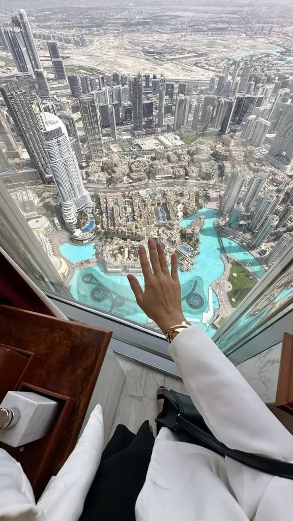 Hand reaching out over Dubai skyline from Burj Khalifa height